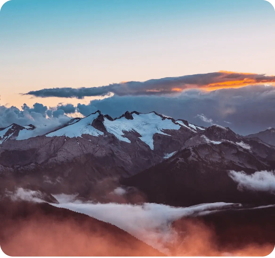 Snow-capped mountains at sunset under a vivid sky
